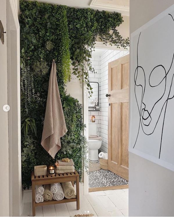 A look in at the bathroom from the hallway with large artwork drawing of a face on the wall