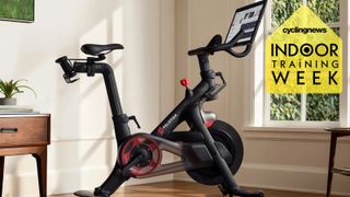 A Peloton bike in a well-lit room with an Indoor Training Week badge overlaid
