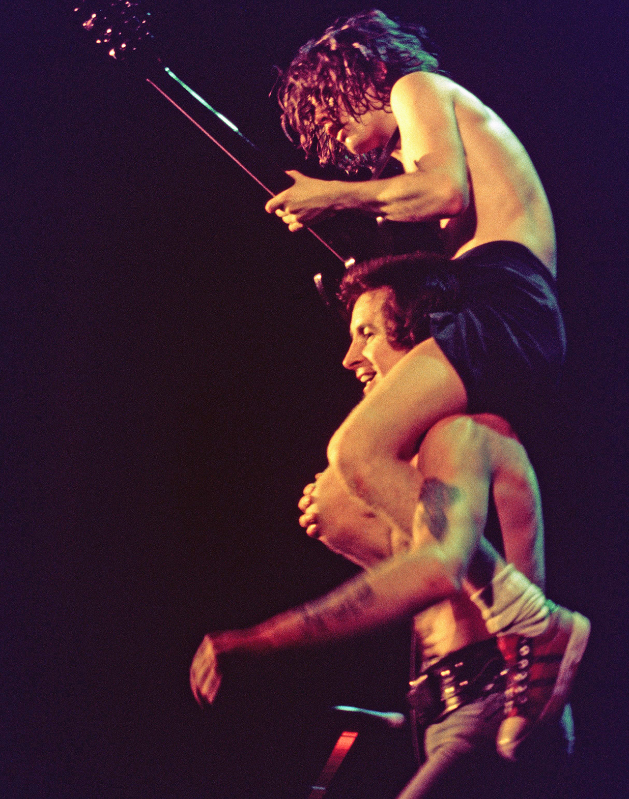 Bon Scott of AC/DC hoists guitarist Angus Young on his shoulders at a gig in February 1977 in Hollywood, California.