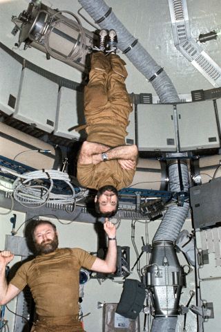 Skylab 4 commander Gerald "Jerry" Carr demonstrates his strength by balancing Bill Pogue on his finger in microgravity.