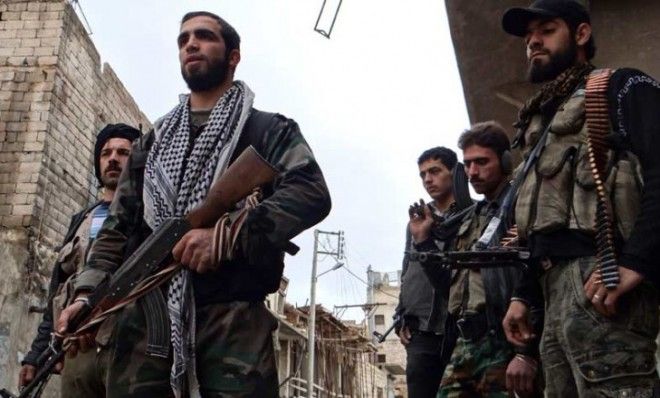 Free Syrian Army fighters carry weapons on a street in Aleppo&amp;#039;s al-Amereya district on Dec. 12.