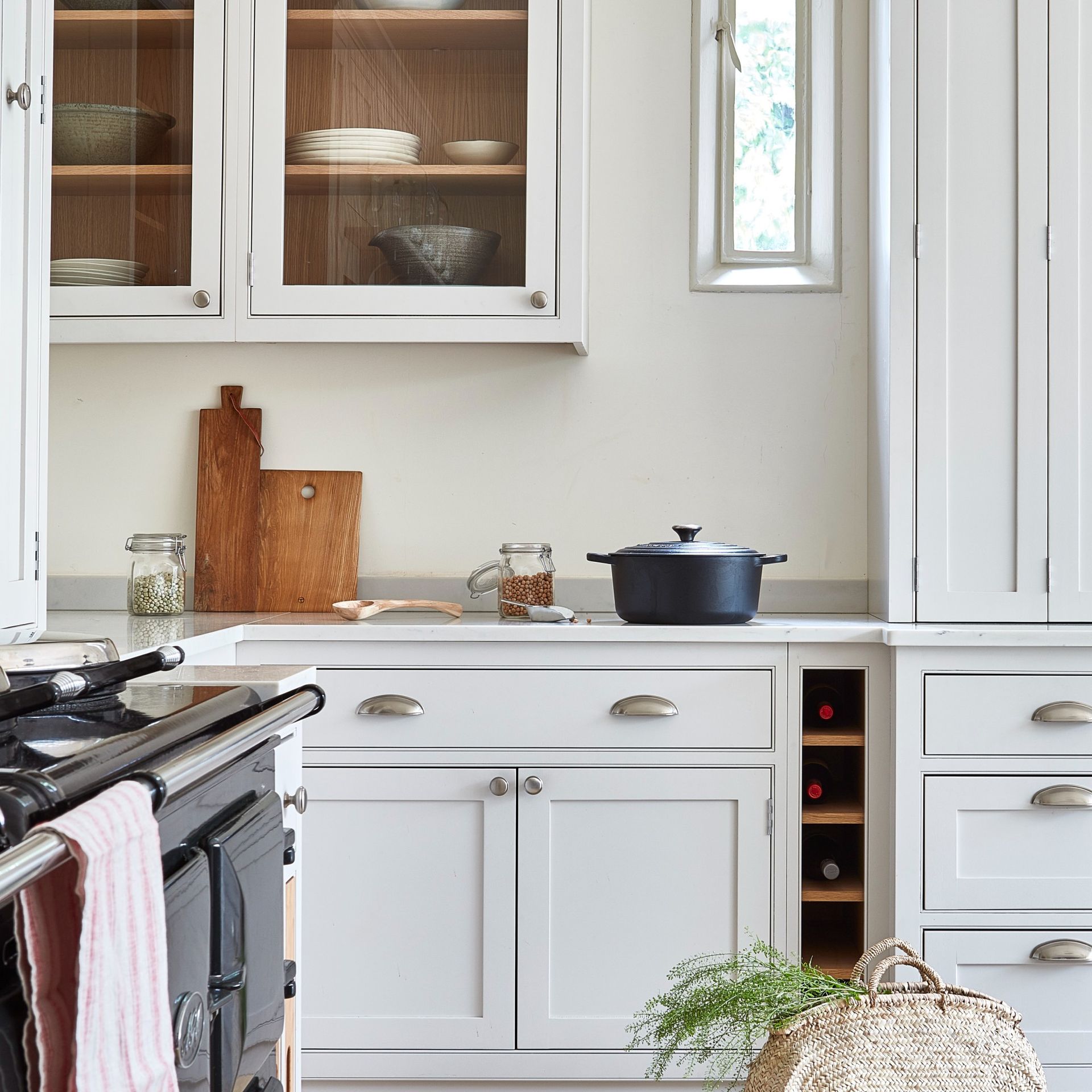 A white kitchen with a Le Creuset cast iron casserole dish on the stove
