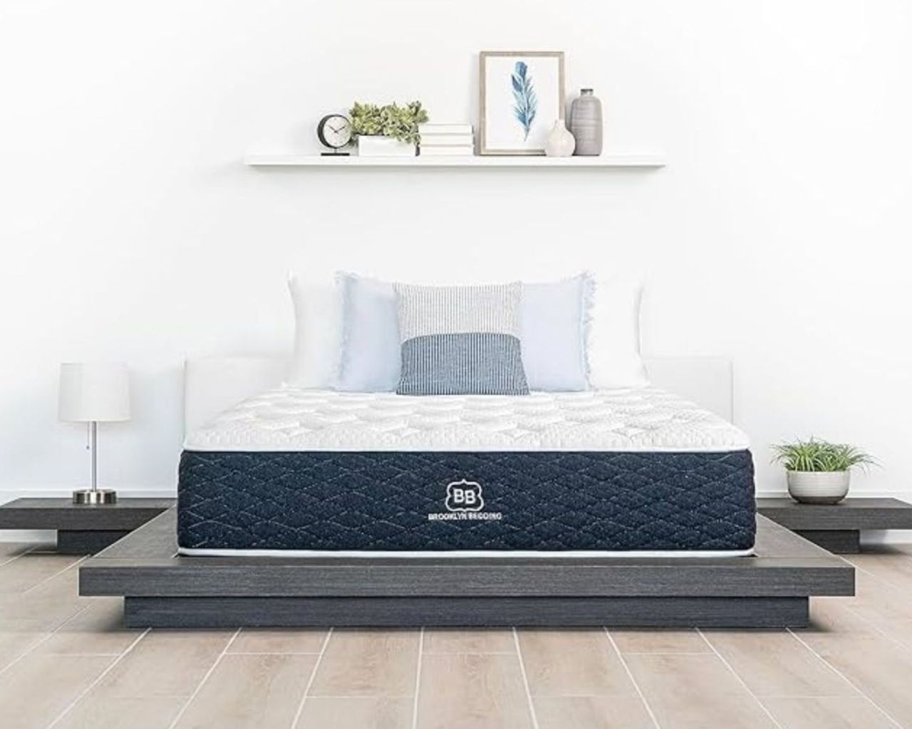 Brooklyn Bedding signature hybrid in a white bedroom with light wood flooring on a dark grey bedframe with matching nightstands