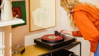 Cambridge Audio Alva ST turntable in lifestyle setting with a woman putting needle on vinyl