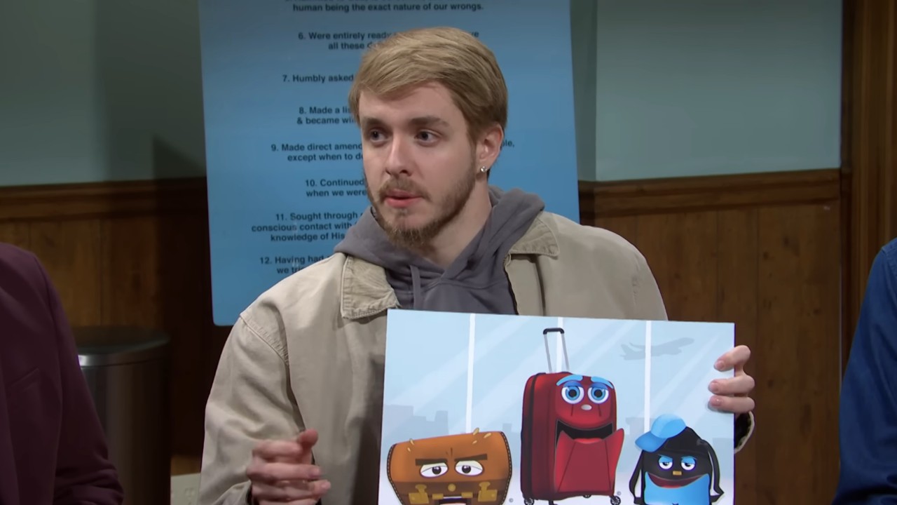 Jack Harlow holding an image of Pixar suit cases on SNL