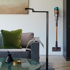 Dyson cordless vacuum cleaner hanging on wall bracket in living room