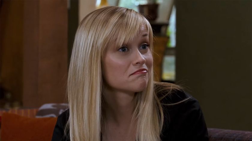 Reese Witherspoon sits on a couch and looks spunky in a screenshot from Four Christmases