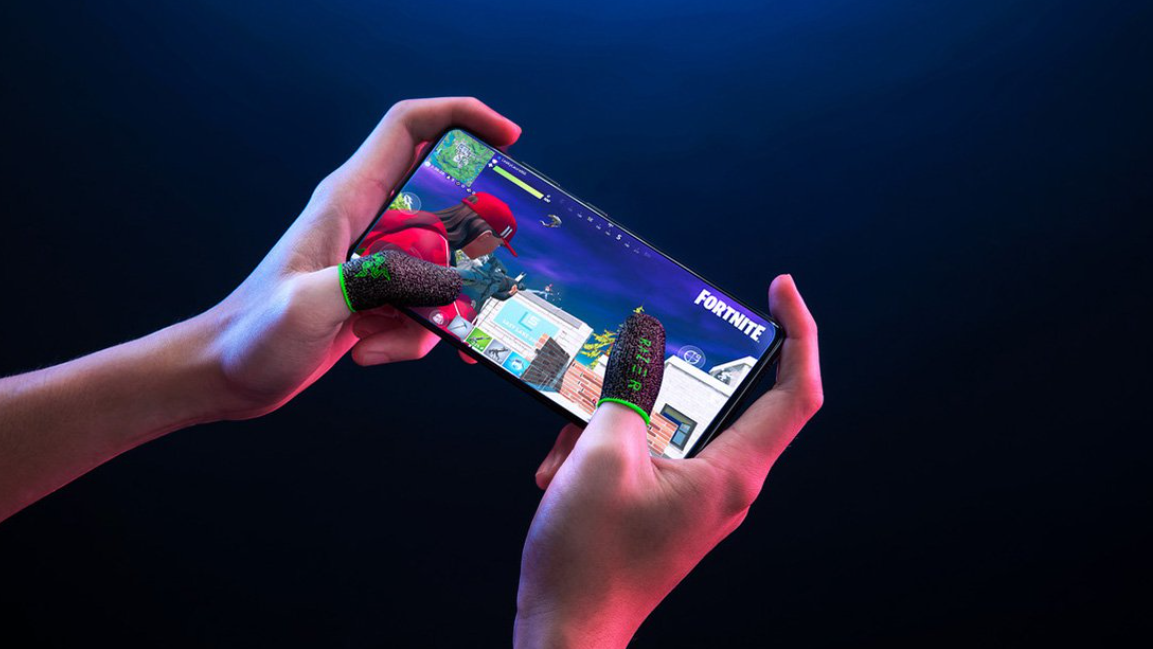 Gaming finger sleeves on thumbs playing Fortnite on a smartphone.