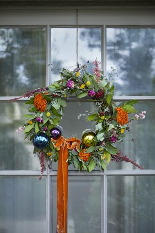 Natural bay and eucalyptus Christmas wreath with baubles and orange velvet ribbon