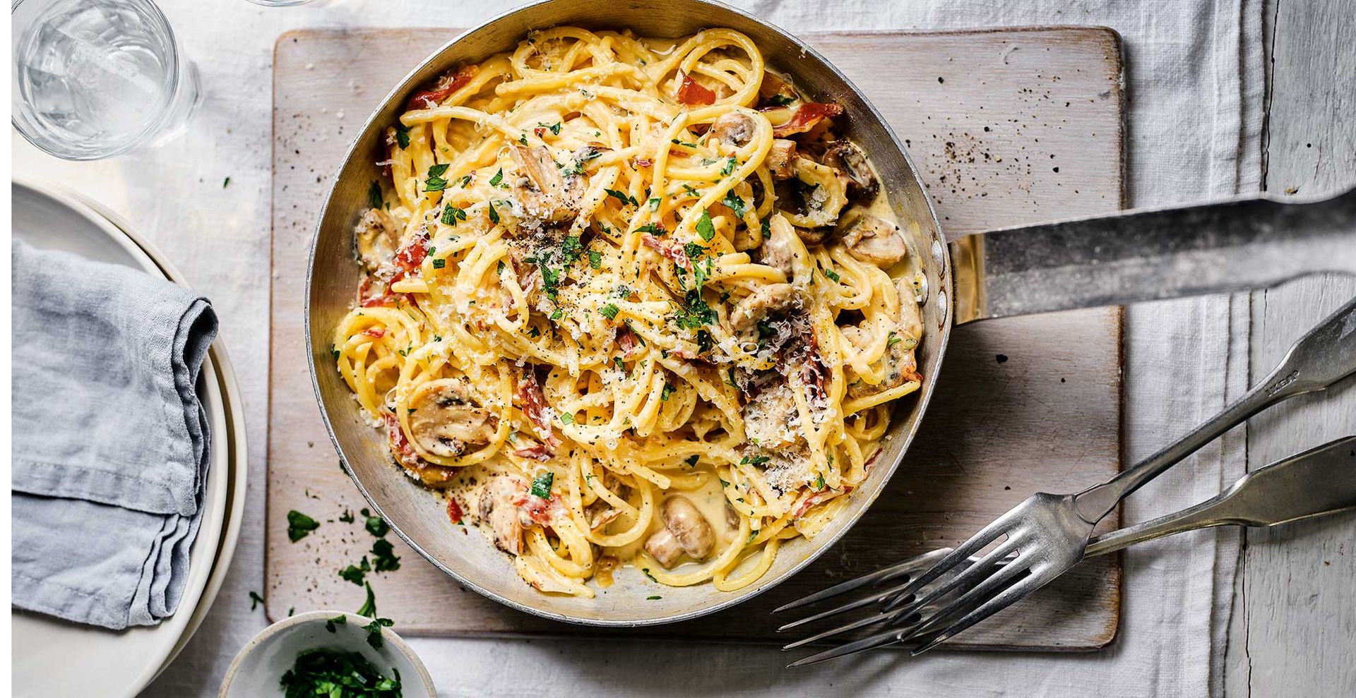 carbonara in saucepan on a gray linen tablecloth