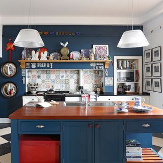 kitchen with navy blue wall and cabinets with wooden worktop