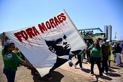 Protesters hold a banner reading "Moraes Out" on alleged links between Supreme Court Justice Alexandre de Moraes and banker Daniel Vorcaro