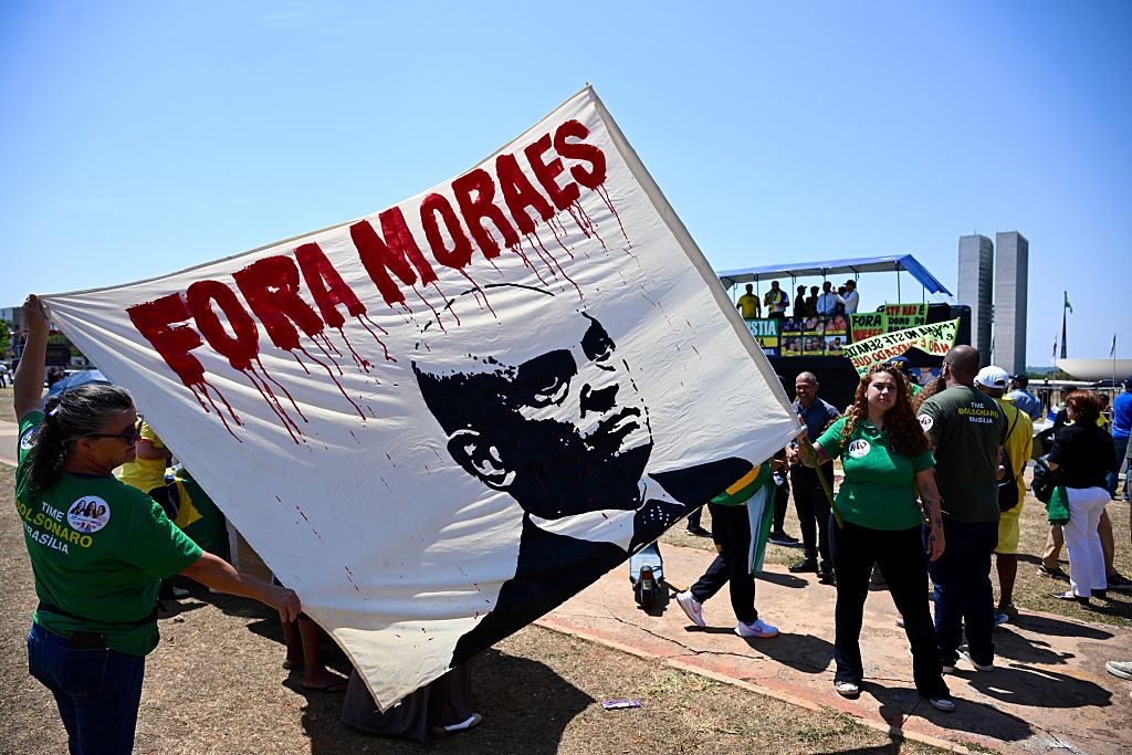 Protesters hold a banner reading "Moraes Out" on alleged links between Supreme Court Justice Alexandre de Moraes and banker Daniel Vorcaro