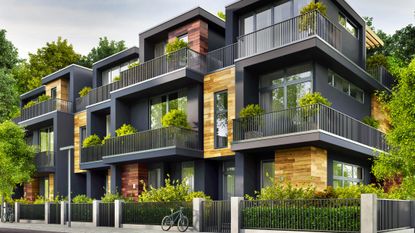An attractive, green apartment building, with bicycle in the foreground.