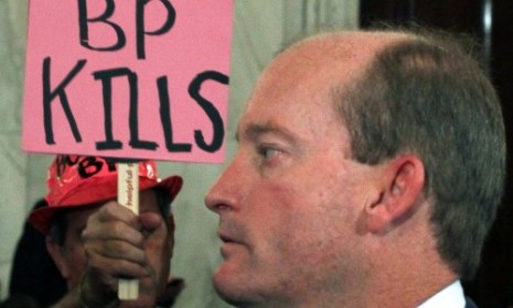 A protestor makes his feelings known to BP president Lamar McKay at yesterday's Senate hearing.