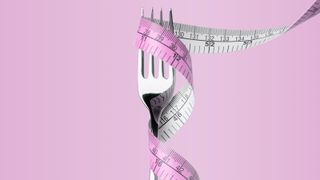 fork and tape measure on pink background