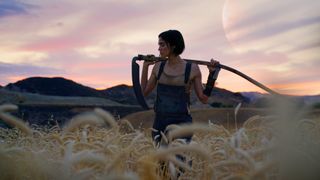 Kora (Sofia Boutella) poses in a field with a sickle in Rebel Moon - Part One: A Child of Fire