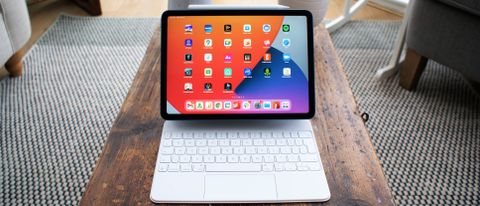 En iPad Air 2022 står på ett träbord i ett vardagsrum.