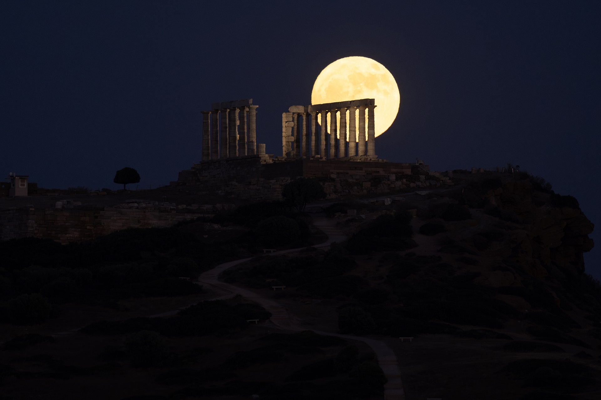 The moon known as 'Strawberry Moon' rises over the Temple of Poseidon on Cape Sounion in Athens, Greece on June 21, 2024