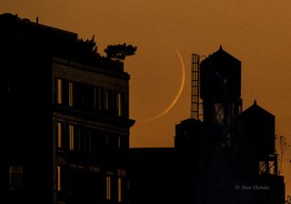 This photo captures the orange glow of the sunset and the crescent moon peaking over the west side of Manhattan, New York.