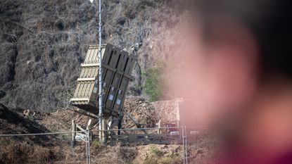 Soldiers stand near an Israeli Air Force Iron dome defense system on November 23, 2023 in Central Israel