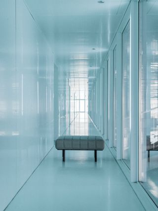 Grey padded bench in a blue corridor