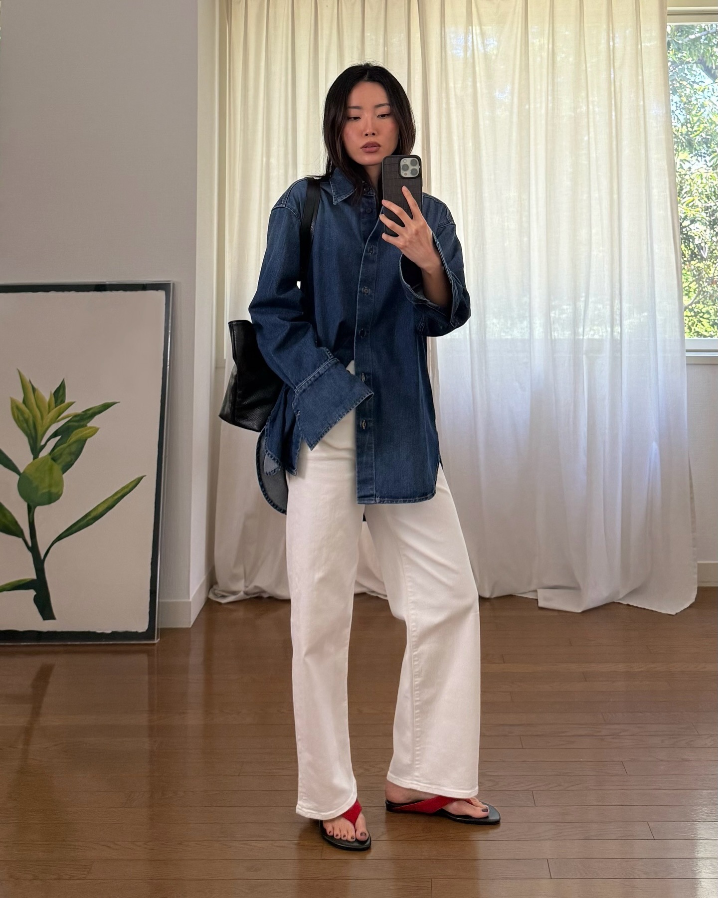 Woman wears denim shirt, white jeans and red flip flops