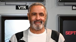 Daley Thompson attends the "September 5" London Premiere at The Historical Curzon Mayfair in a white t-shirt and black and white striped cardigan