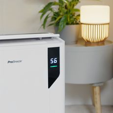 Pro Breeze dehumidifier beside table with lamp