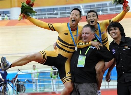 Malaysia's Josiah Ng, left, and Azizulhasni Awang celebrate their respective silver and gold medals in the men's keirin.