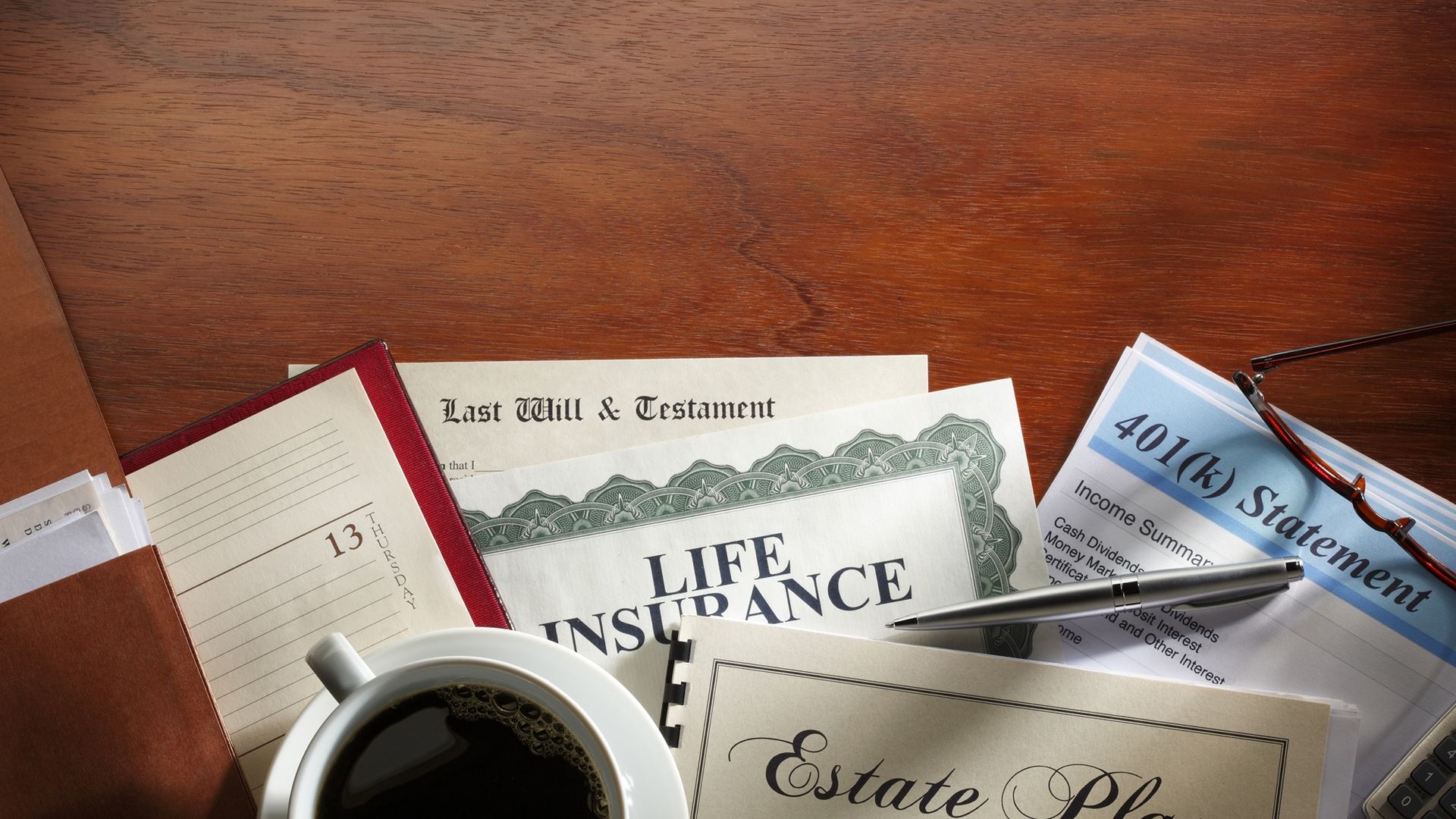 A desk scene with many documents related to estate planning.