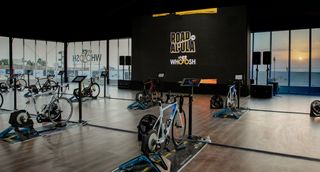 A number of bikes set up on smart trainers in a room 