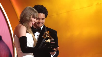 Taylor Swift receives a Grammy Award from host Trevor Noah at the 2024 ceremony