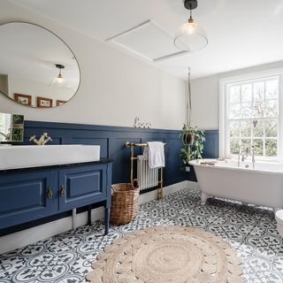 bathroom with white and blue panel wall bathtub white window