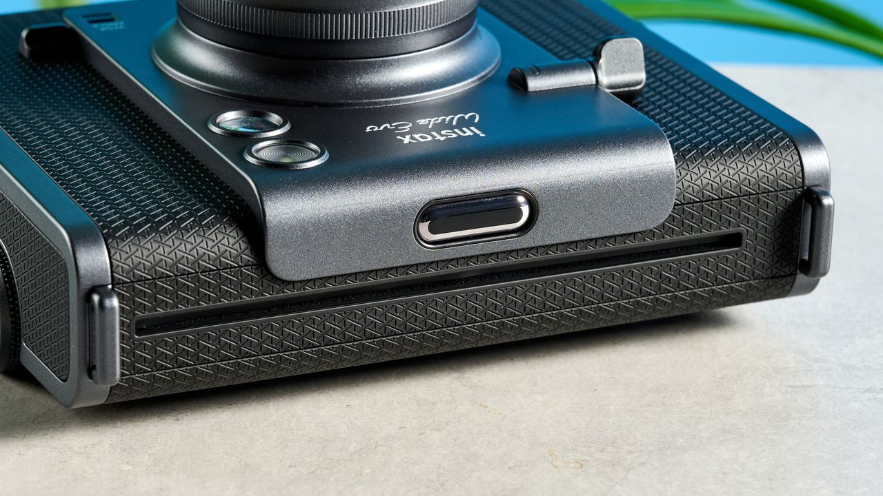A black and gray Fujifilm Instax Wide Evo hybrid instant camera