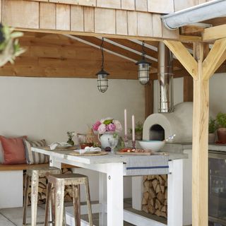 outdoor island on patio in front of pizza oven and bench seating