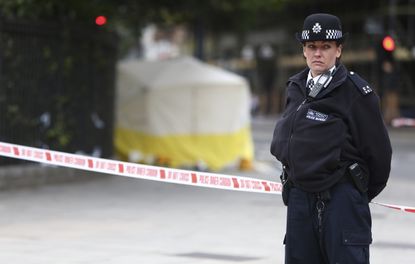 A police officer guards the scene of a stabbing in London