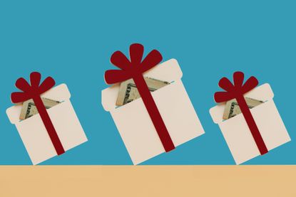 three holiday presents with red bows and money inside