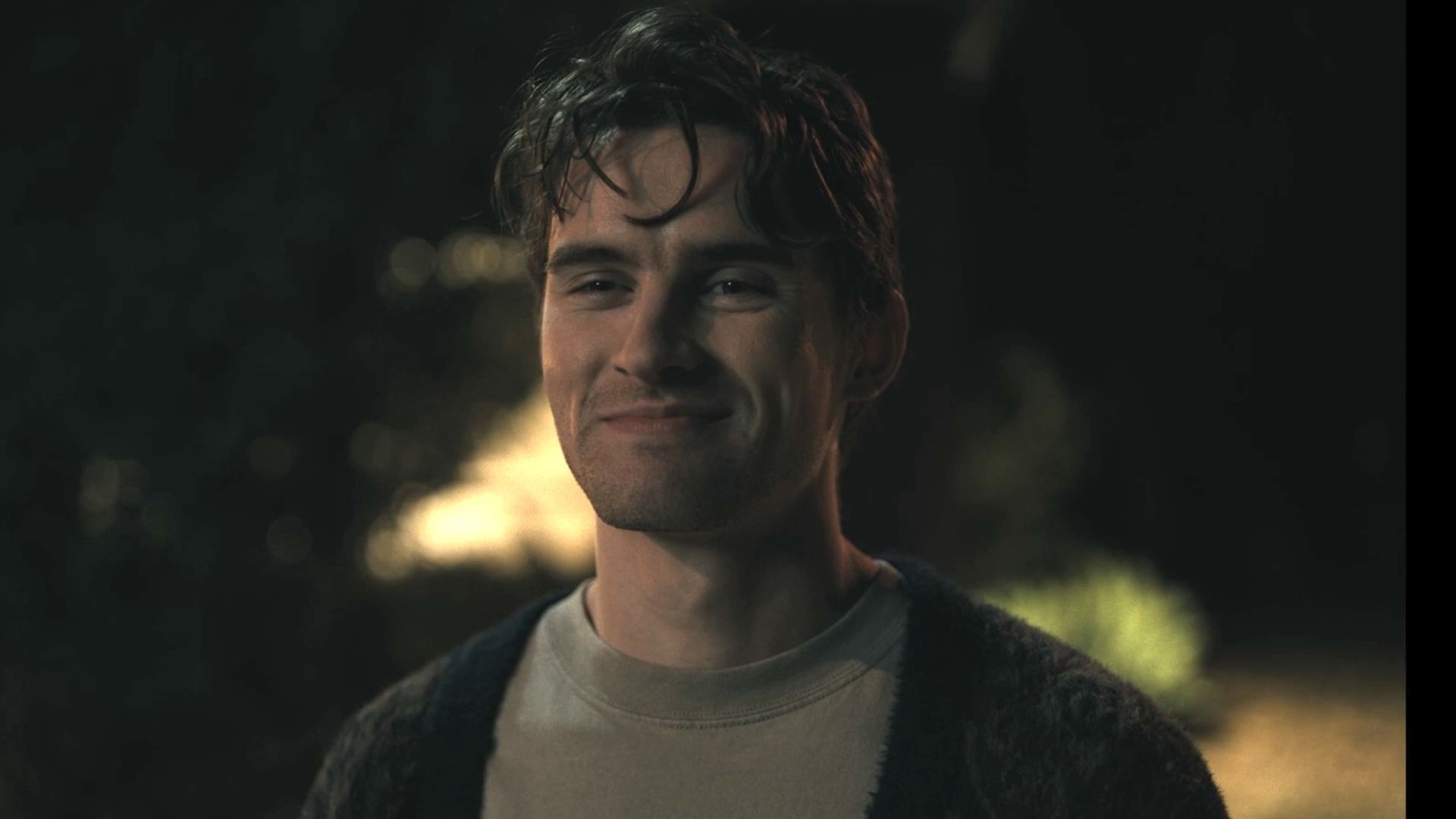 Bear wearing a cardigan smiling at Nikki in the parking lot.