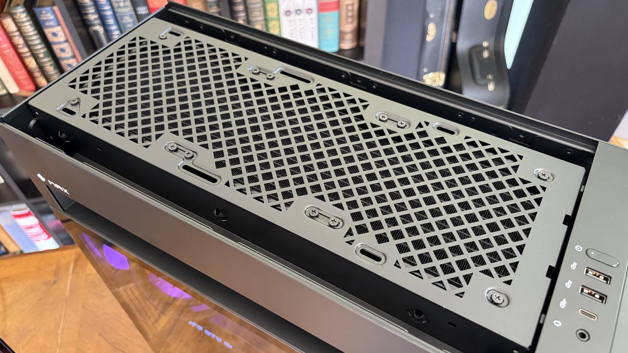 Top view of a black Omen Max 45L computer case with a ventilated mesh panel and ports on the side, set against a background of bookshelves.