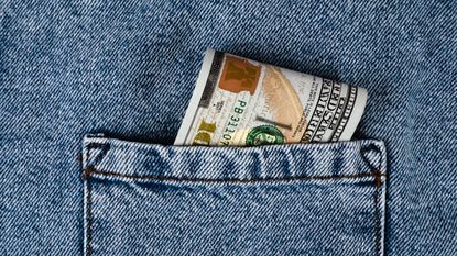 Money folded up in a denim pocket.