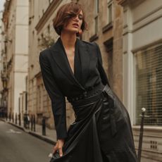 Model on a street wearing an all black outfit