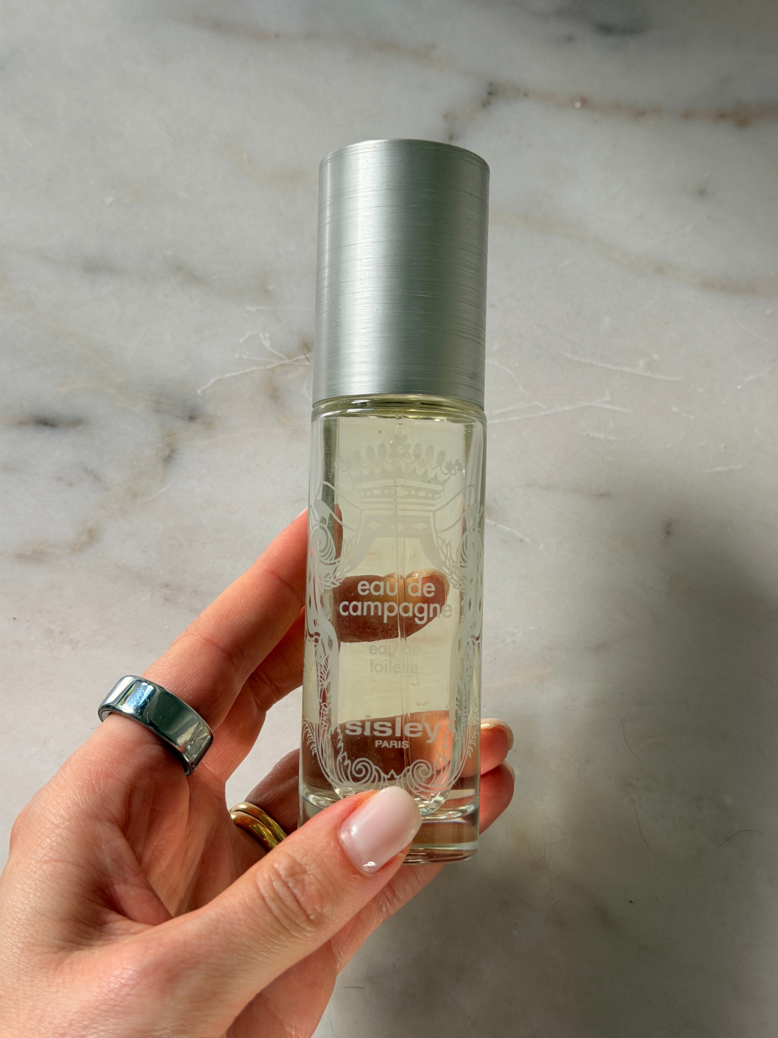 Grace holding a bottle of Sisley perfume