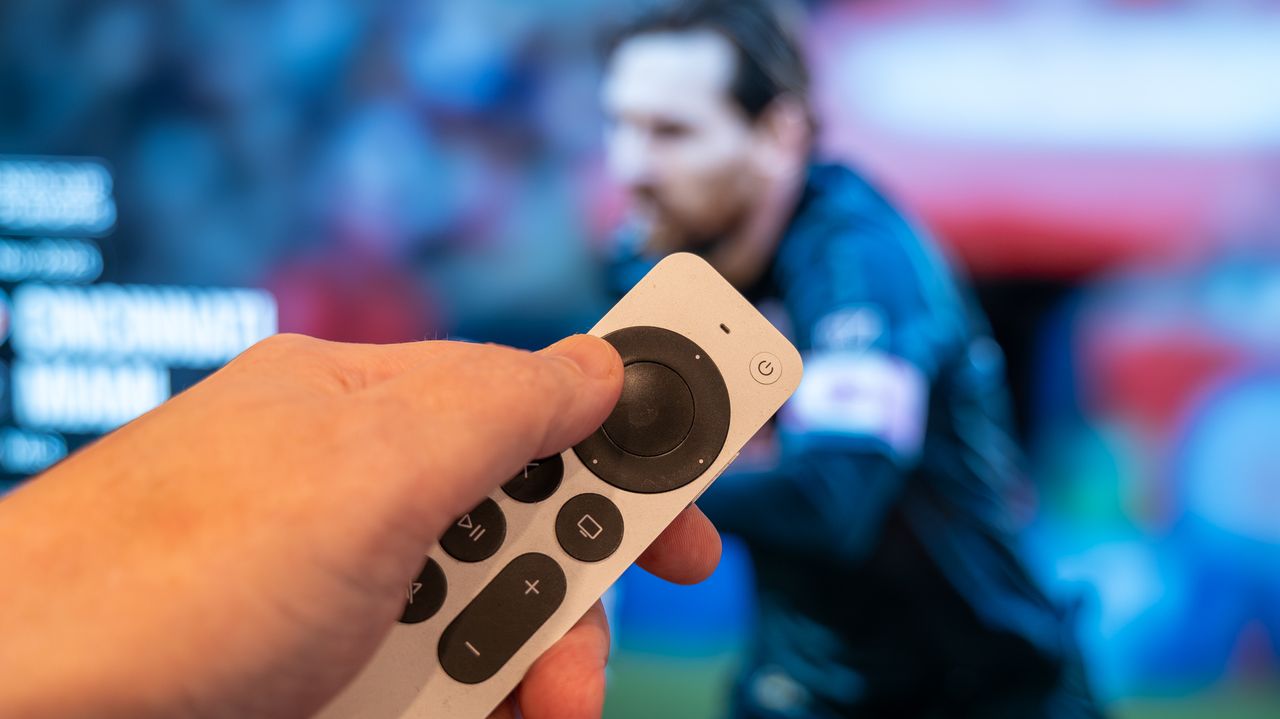 Apple TV remote pointing at screen showing Lionel Messi