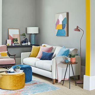 grey living room with yellow accent trim and neutral sofa