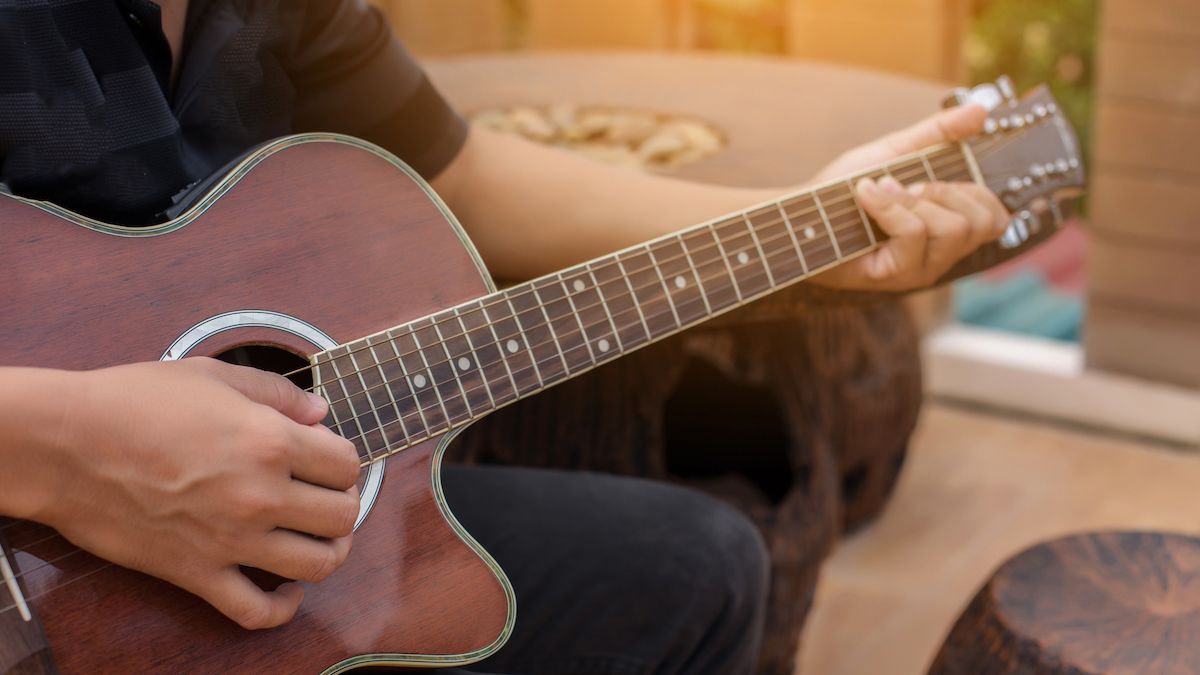 Man playing acoustic guitar in his garden