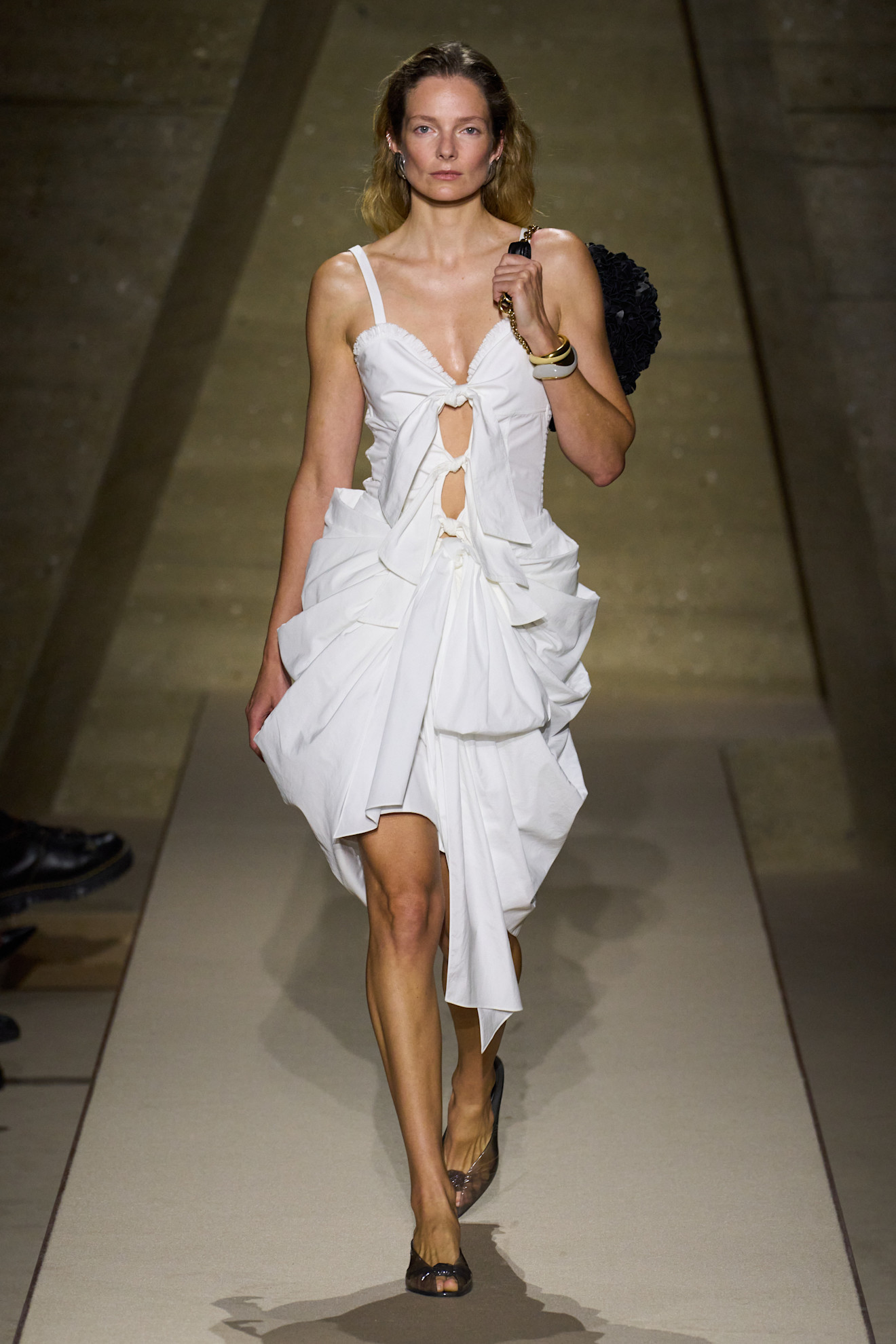 A Chloé model at the S/S 26 show wearing a white dress with peep-toe heels.
