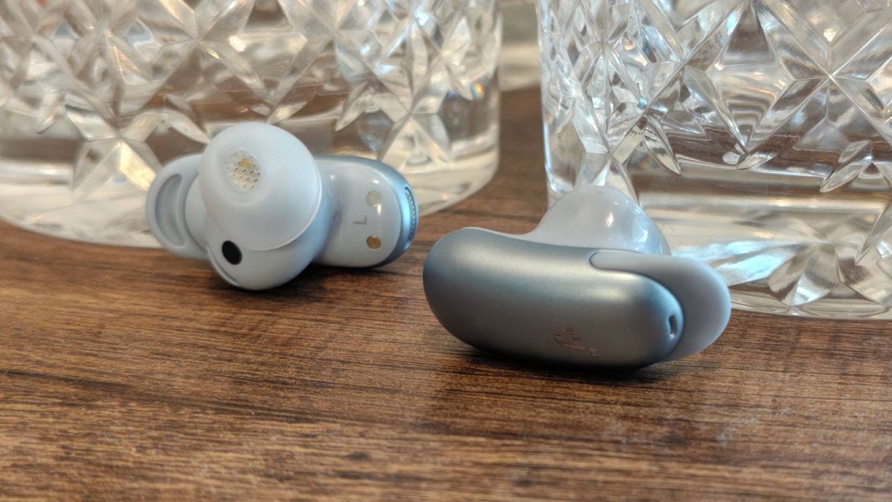 The Anker Soundcore Liberty 5 Pro on a shelf, next to some glasses.