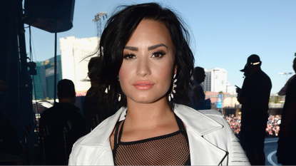 Demi Lovato pouting, wearing make up and white leather jacket