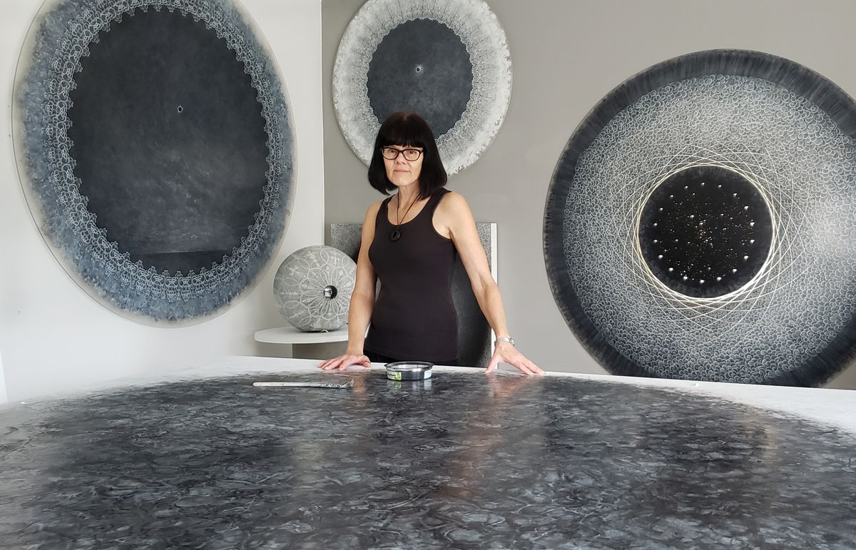 Artist Carol Prusa surrounded by her astronomy-inspired silverpoint artwork.